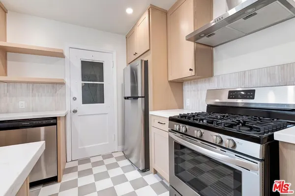 a kitchen with stainless steel appliances granite countertop a stove a refrigerator and a cabinets