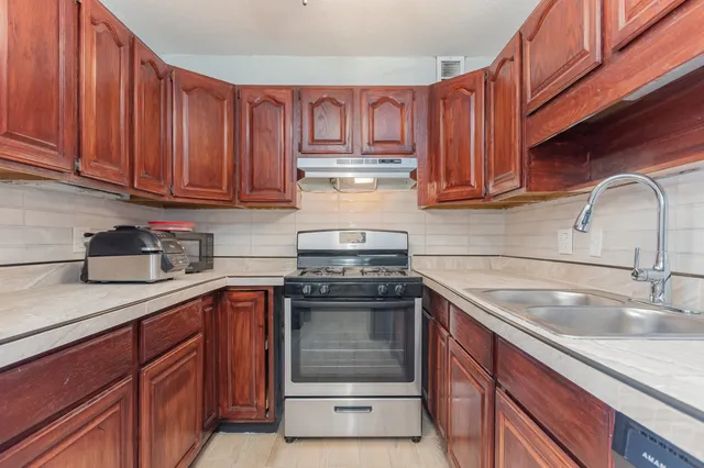 a kitchen with a sink stove and cabinets