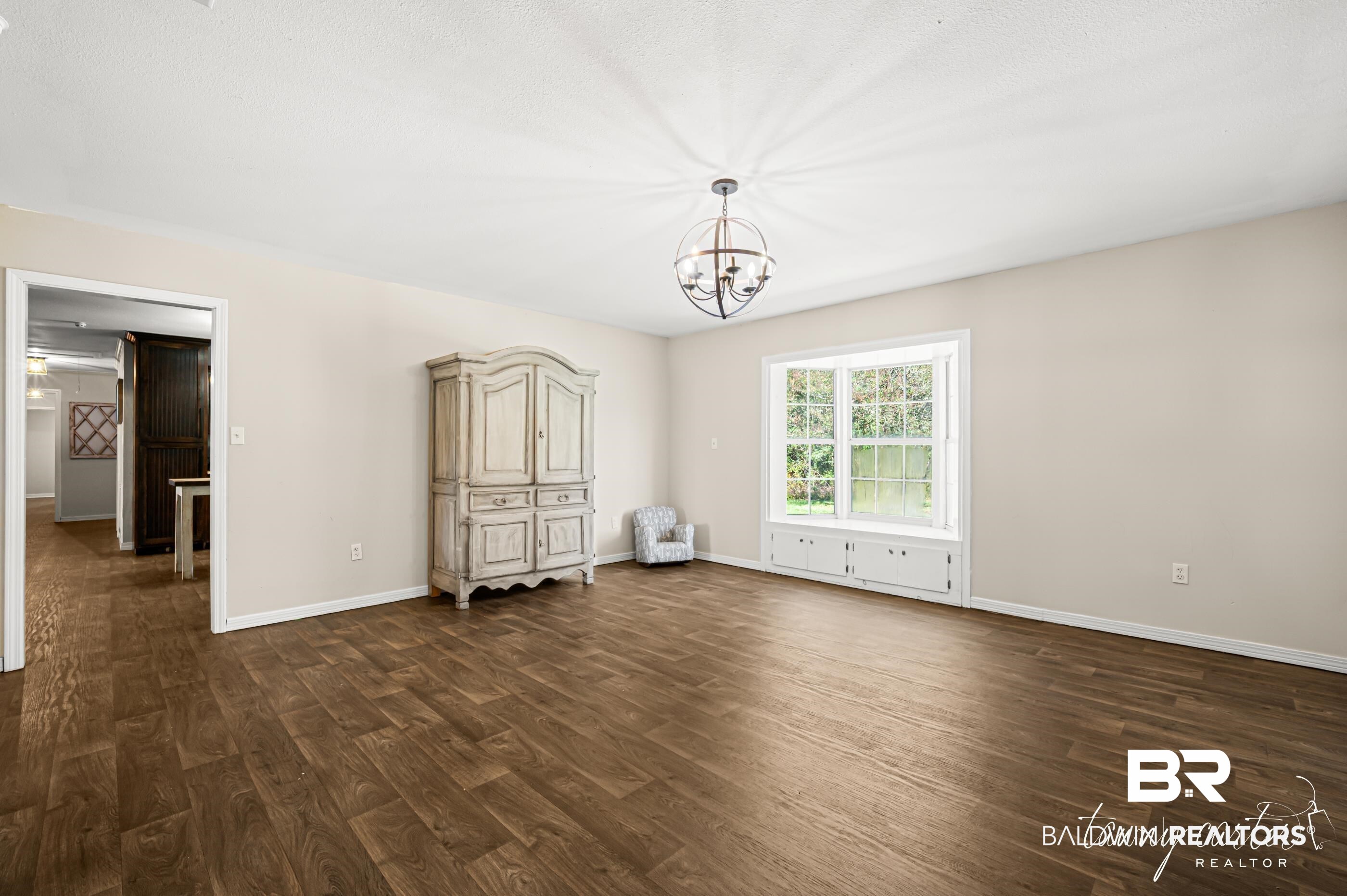 3086 Wild Fork Road Frisco City, AL 36445 - Photo 16 of 30 Unfurnished bedroom with dark wood-style flooring and a chandelier