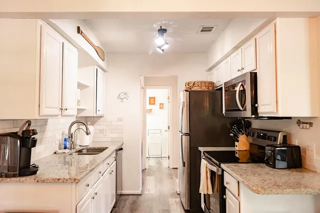 a kitchen with stainless steel appliances granite countertop a sink stove and refrigerator