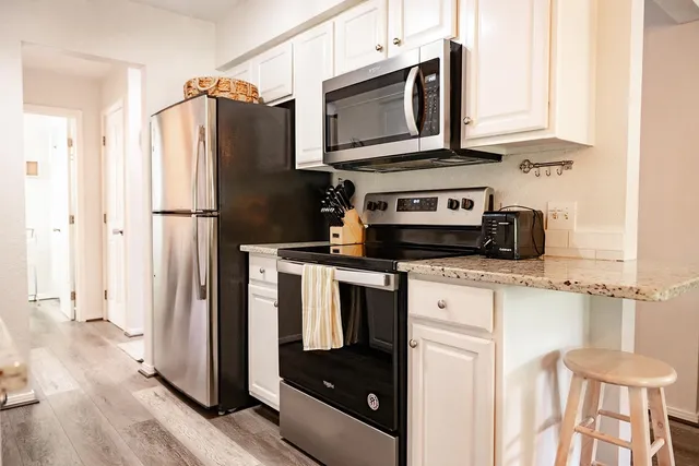 a kitchen with stainless steel appliances a stove microwave and refrigerator