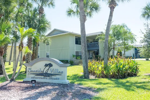 a view of a swimming pool with a yard and a large tree