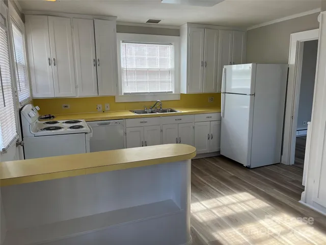a kitchen with a stove a refrigerator and a sink