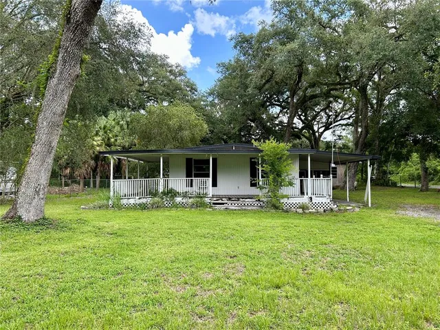 a front view of a house with a garden and trees