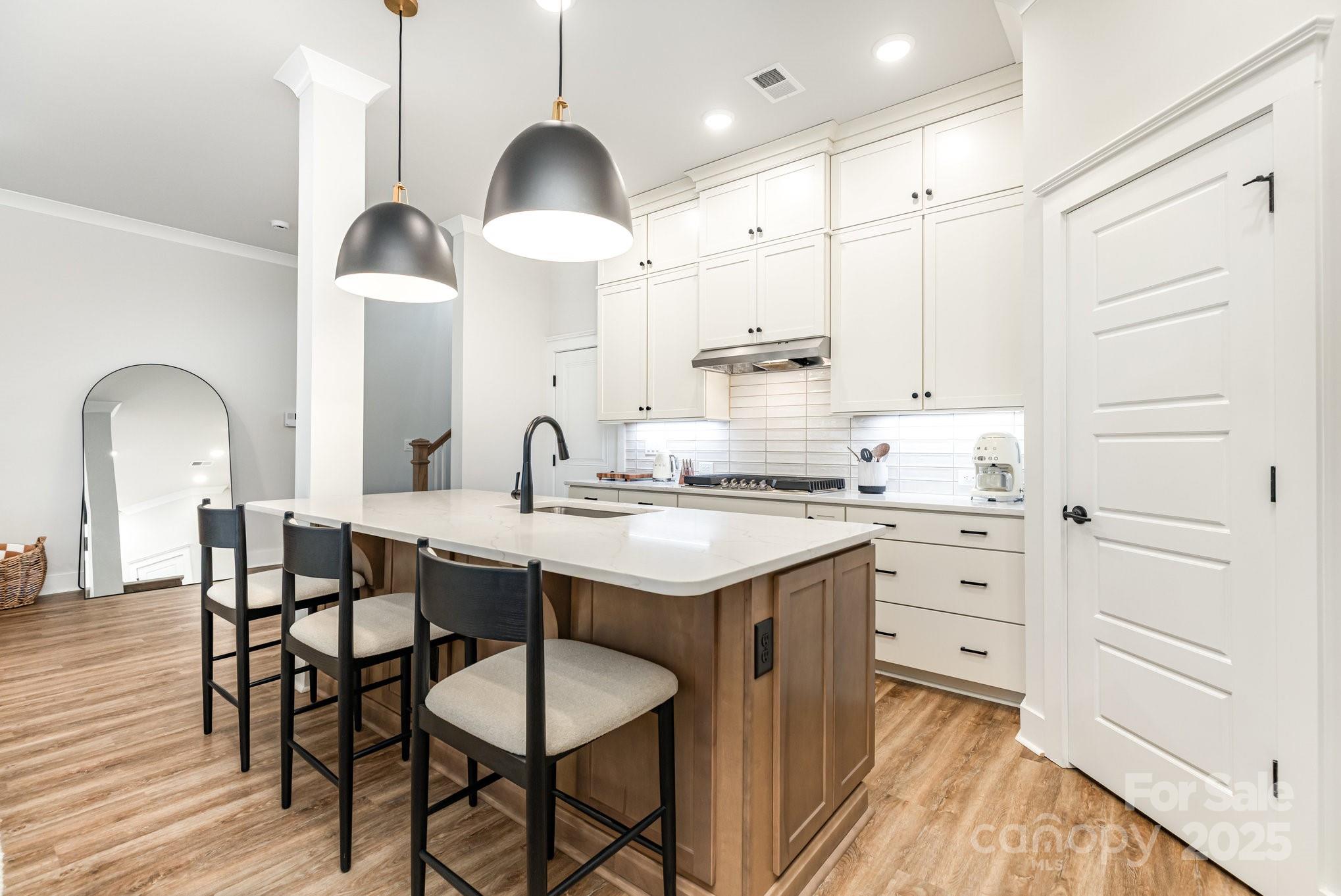 8014 Houser Street Cornelius, NC 28031 - Photo 8 of 24 a kitchen with stainless steel appliances kitchen island granite countertop a table chairs sink and cabinets