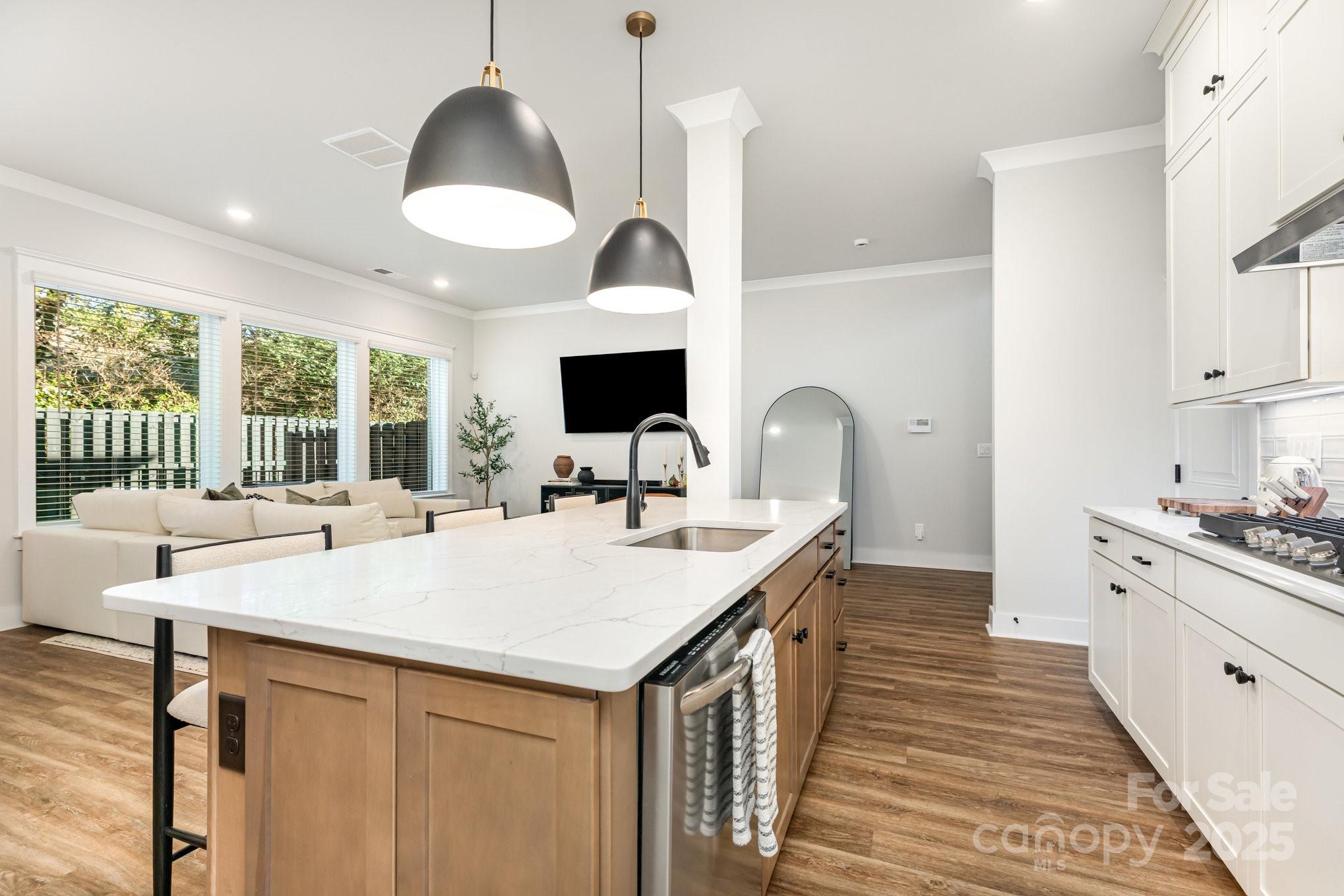 8014 Houser Street Cornelius, NC 28031 - Photo 9 of 24 a large kitchen with kitchen island a large counter space a sink appliances and a large window
