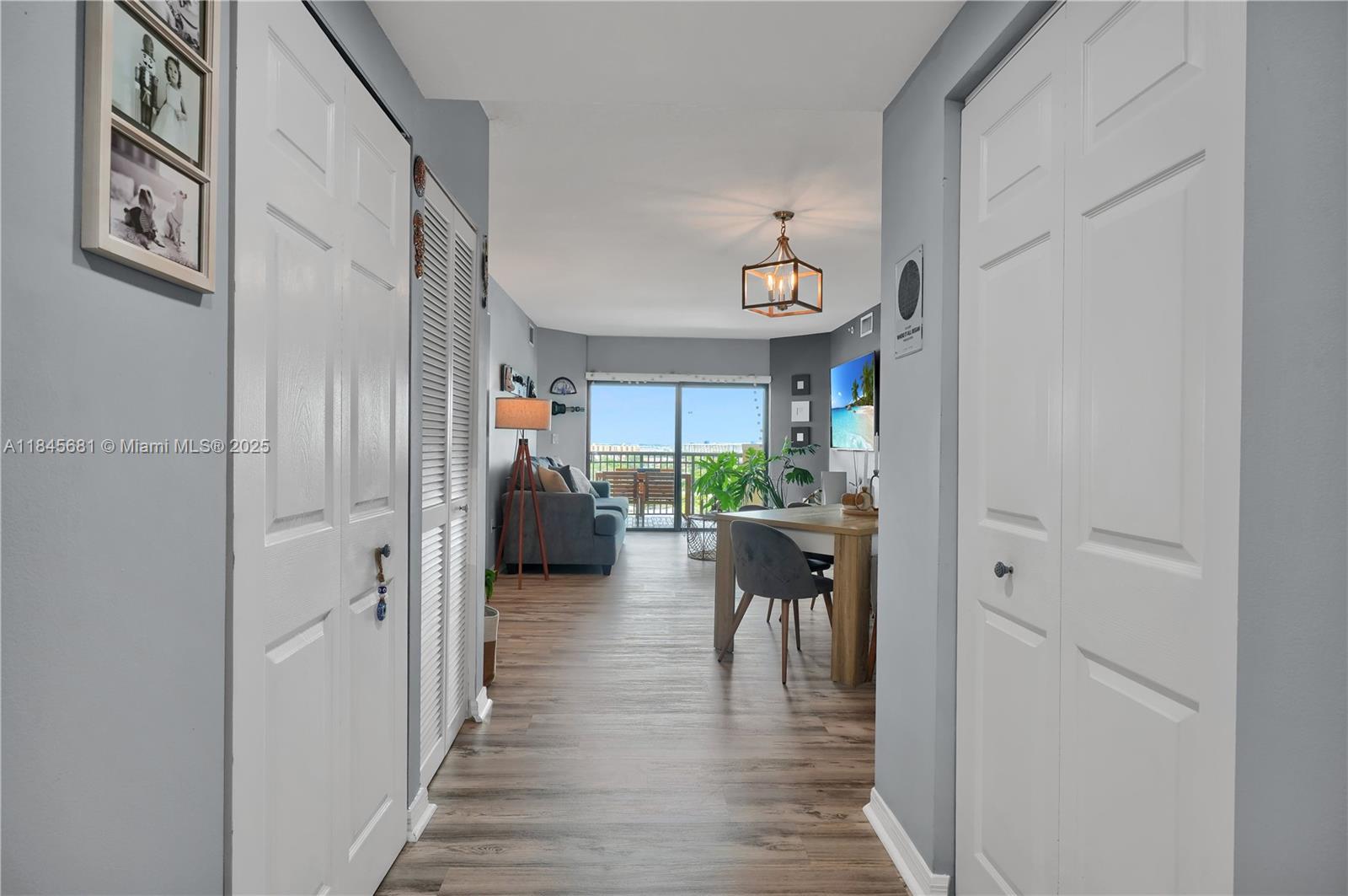 4242 Northwest 2nd Street, Unit 804 Miami, FL 33126 - Photo 17 of 30 a view of a hallway with wooden floor and dining room