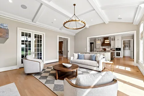 a view of a dining room and livingroom with furniture wooden floor a chandelier