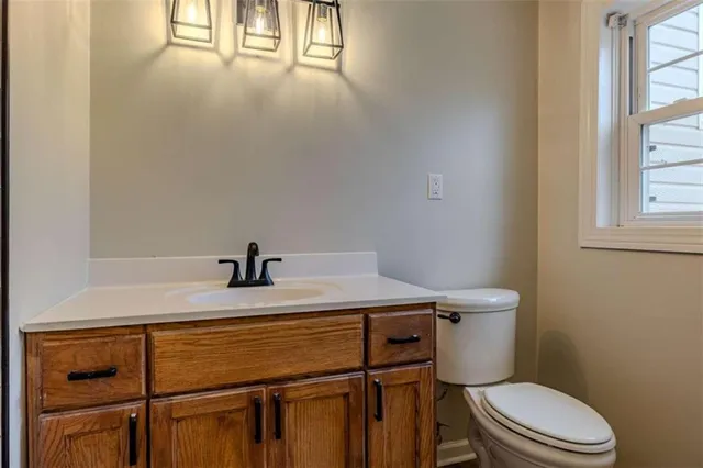 a bathroom with a sink a toilet and window