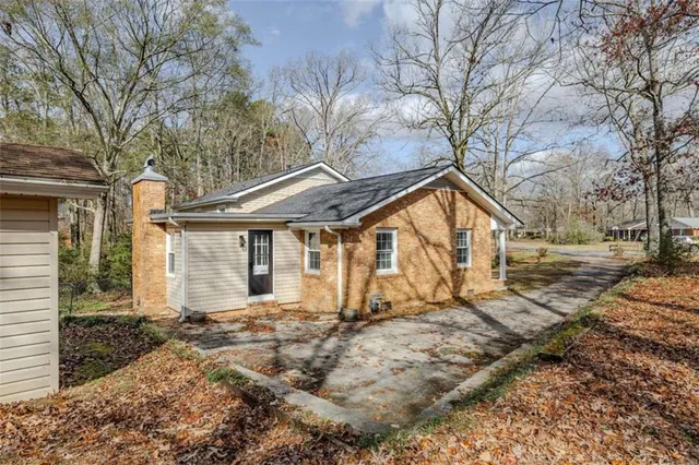a front view of a house with a yard and large tree