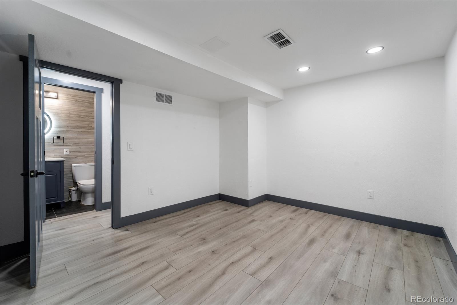 104 Stuart Street Denver, CO 80219 - Photo 16 of 18 wooden floor in an empty room with a window