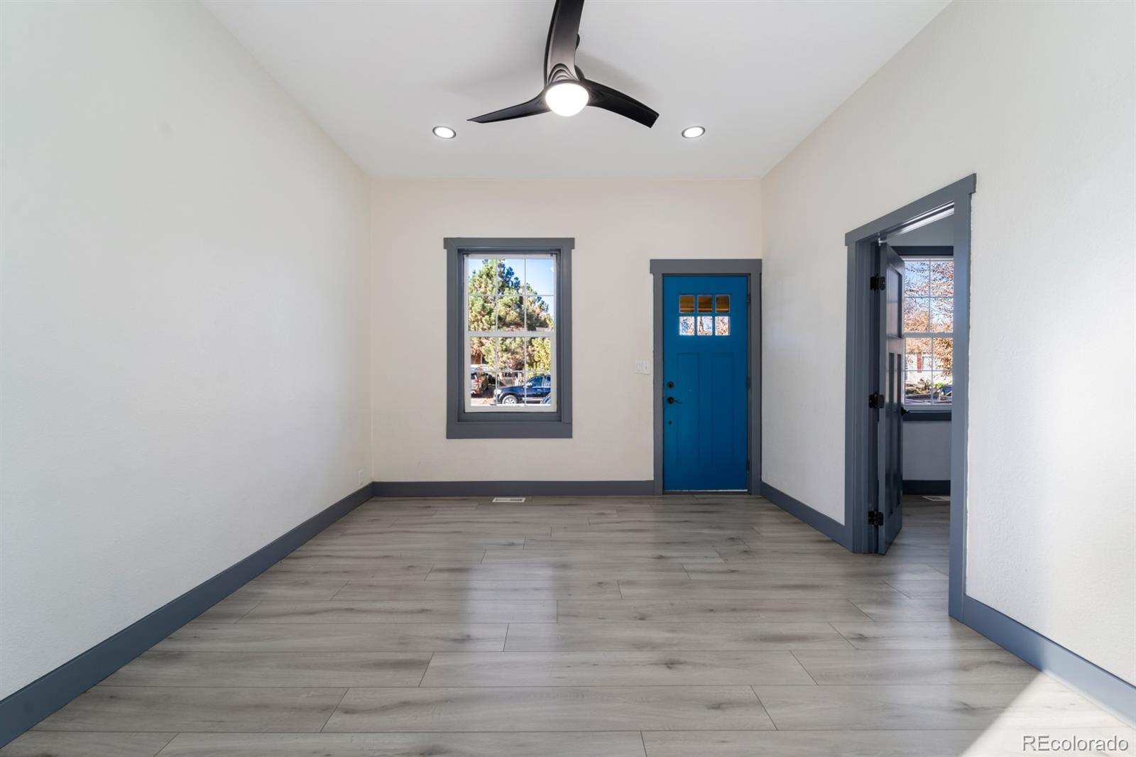 104 Stuart Street Denver, CO 80219 - Photo 4 of 18 wooden floor in an empty room with a window