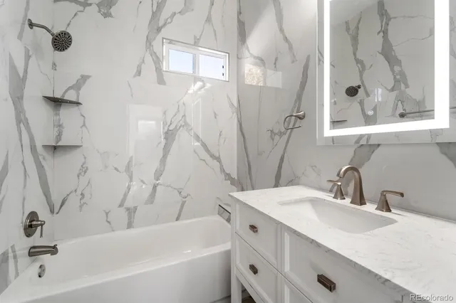 a bathroom with a tub sink and mirror