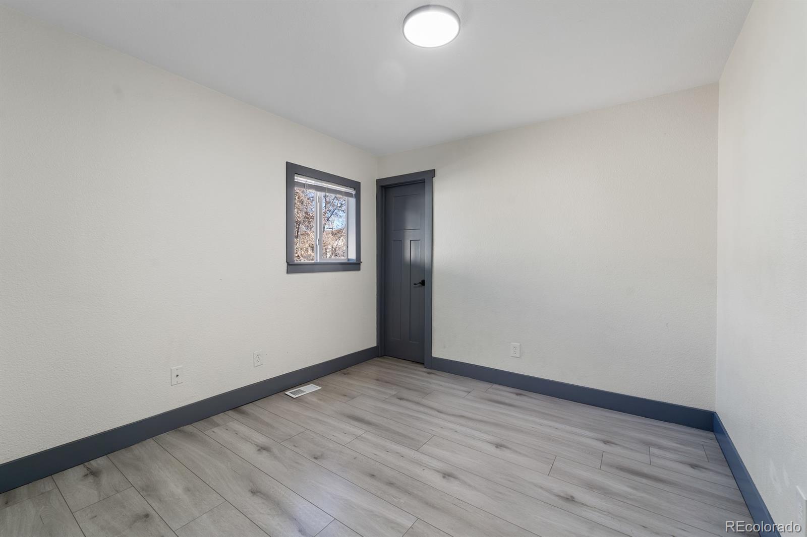 104 Stuart Street Denver, CO 80219 - Photo 10 of 18 an empty room with wooden floor and windows