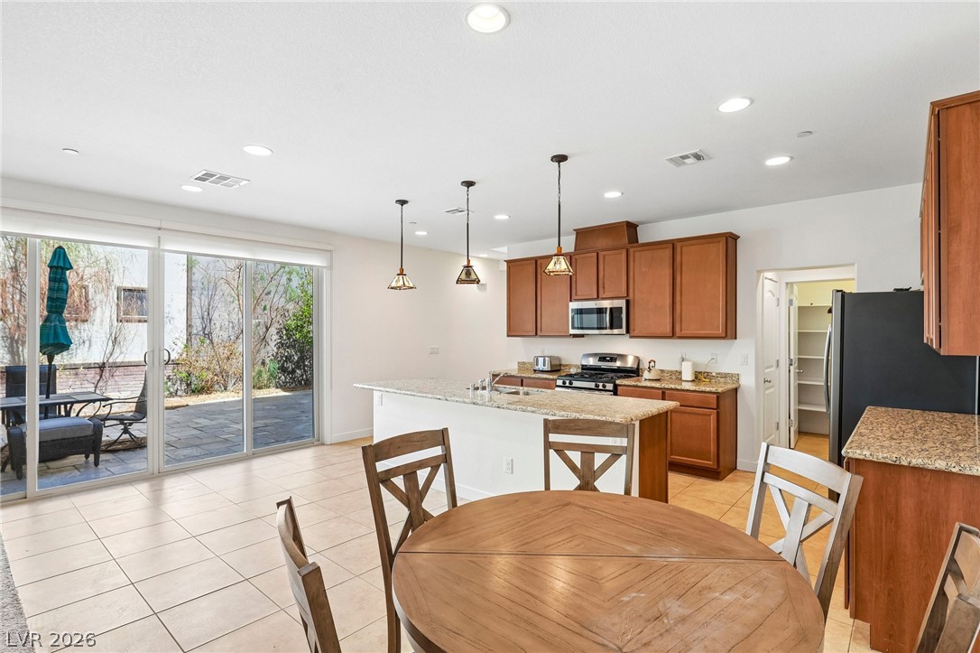 1100 East Sunset Road Henderson, NV 89011 - Photo 11 of 63 Stone countertops and tile flooring define this bright culinary space with sliding glass doors.