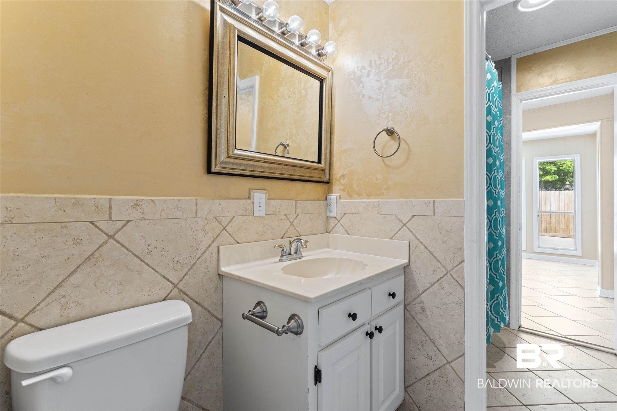 3724 Claridge Road South Mobile, AL 36608 - Photo 25 of 42 Full bath with vanity, curtained shower, wainscoting, and tile walls