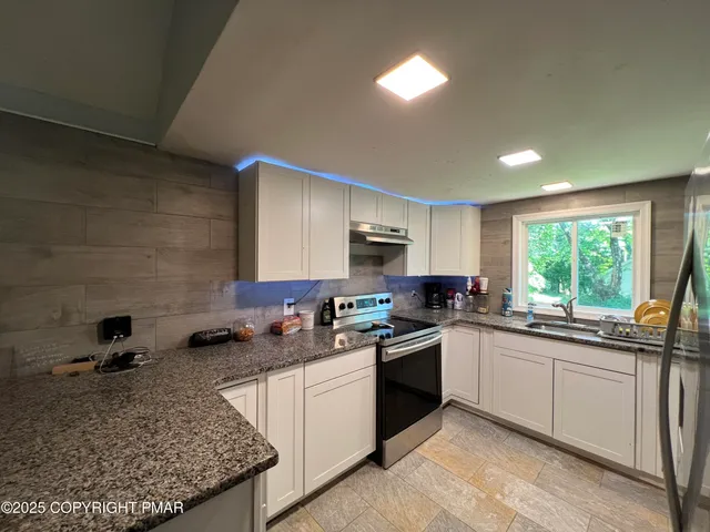 a kitchen with a sink stove and cabinets