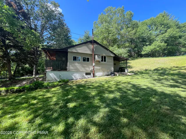 a house is sitting in middle od the grass