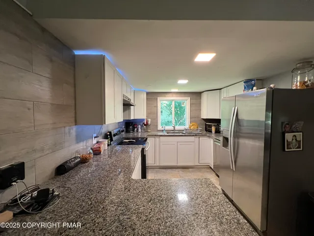 a kitchen with a refrigerator and a sink