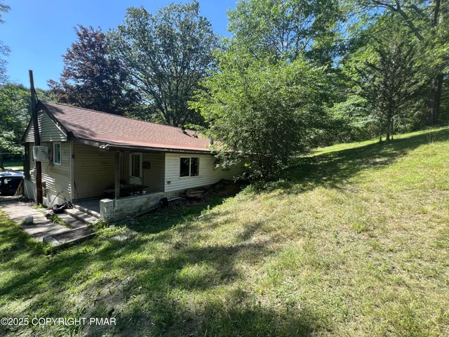 a view of a house with backyard and sitting area