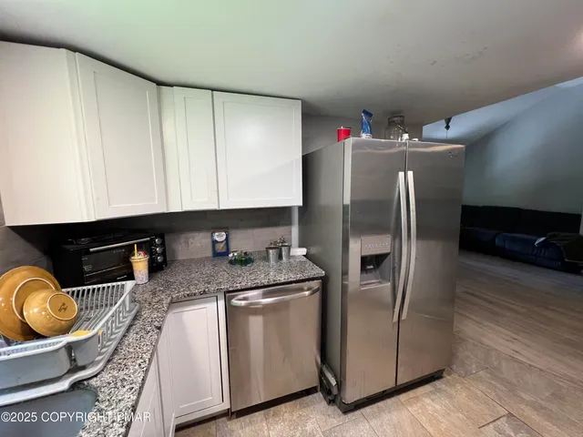 a kitchen with stainless steel appliances granite countertop a refrigerator a stove and a sink