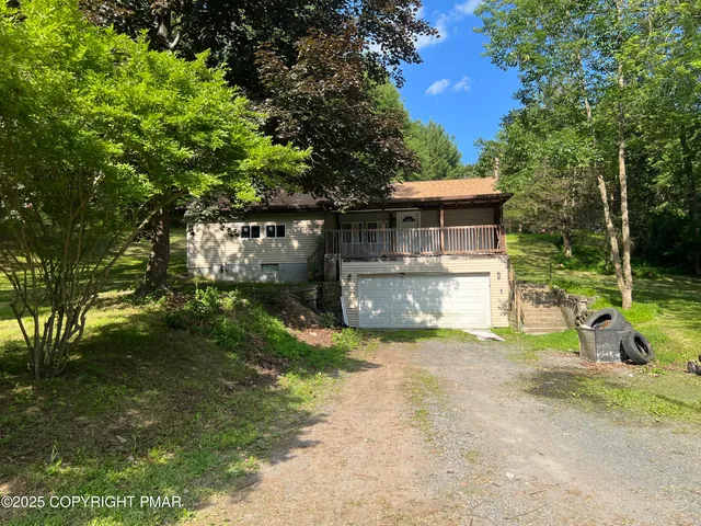 a view of a house with backyard and a tree