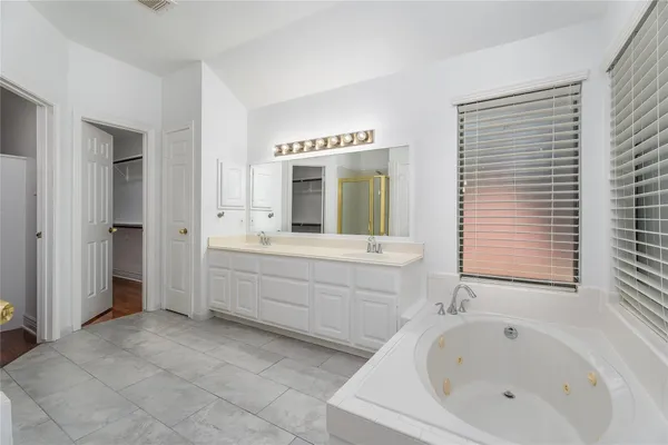 a spacious bathroom with a bathtub sink and mirror