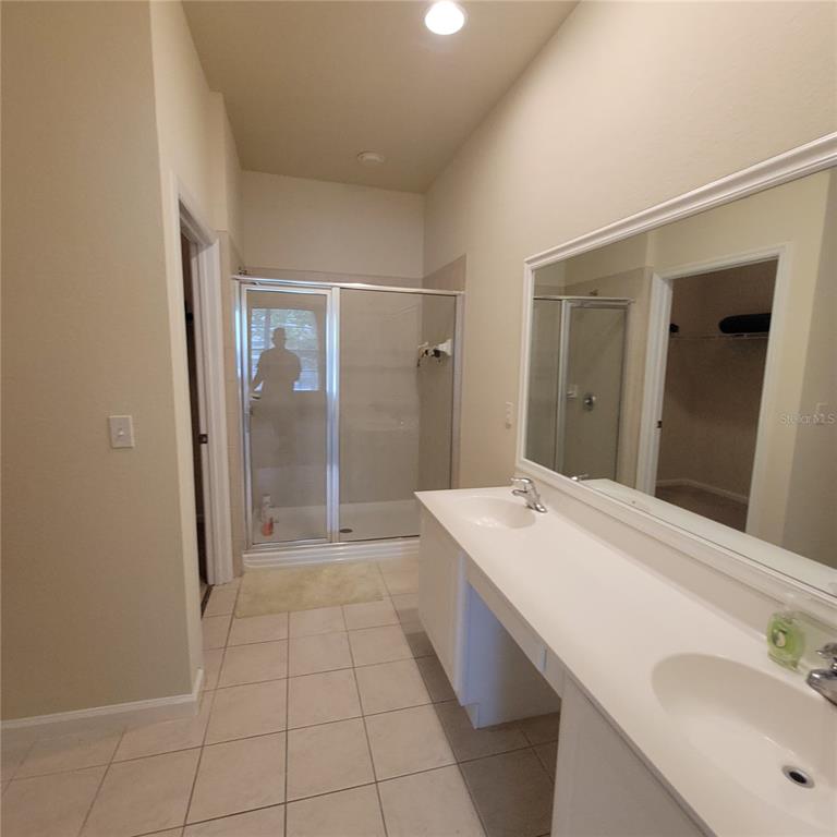 3351 Whitestone Circle, Unit 105 Kissimmee, FL 34741 - Photo 18 of 22 a bathroom with a sink a shower and a mirror