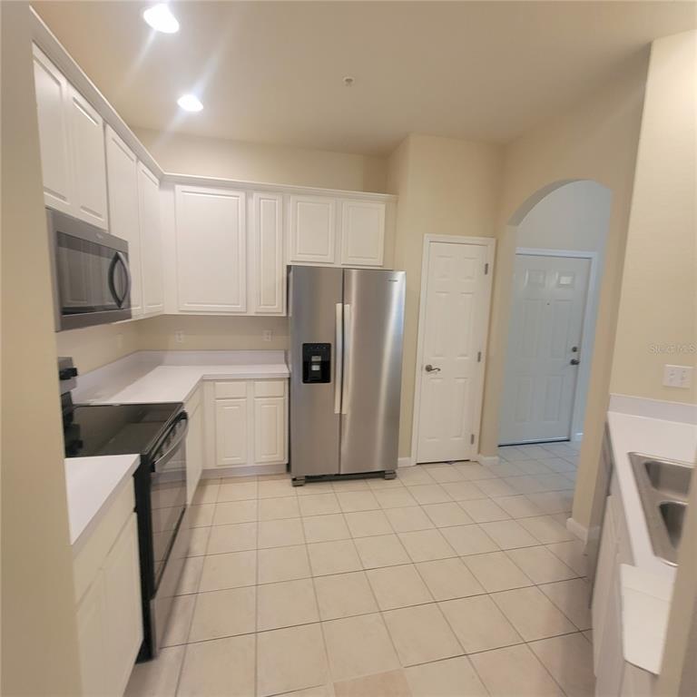3351 Whitestone Circle, Unit 105 Kissimmee, FL 34741 - Photo 7 of 22 a kitchen with a refrigerator sink and cabinets