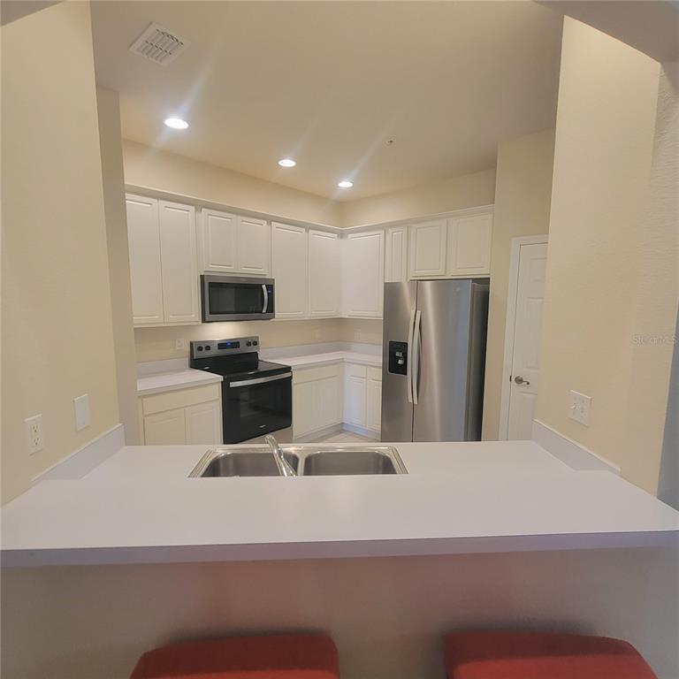 3351 Whitestone Circle, Unit 105 Kissimmee, FL 34741 - Photo 9 of 22 a kitchen with a refrigerator and a stove top oven