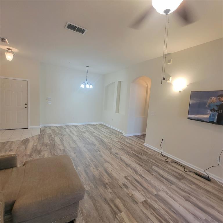 3351 Whitestone Circle, Unit 105 Kissimmee, FL 34741 - Photo 10 of 22 a view of a room with wooden floor and ceiling fan