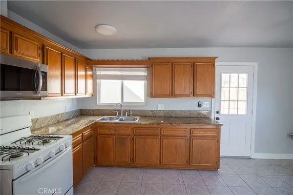 a kitchen with a sink stove top oven and cabinets