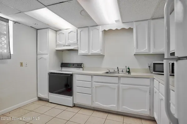 a kitchen with white cabinets and white appliances