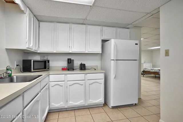 a white refrigerator freezer sitting inside of a kitchen