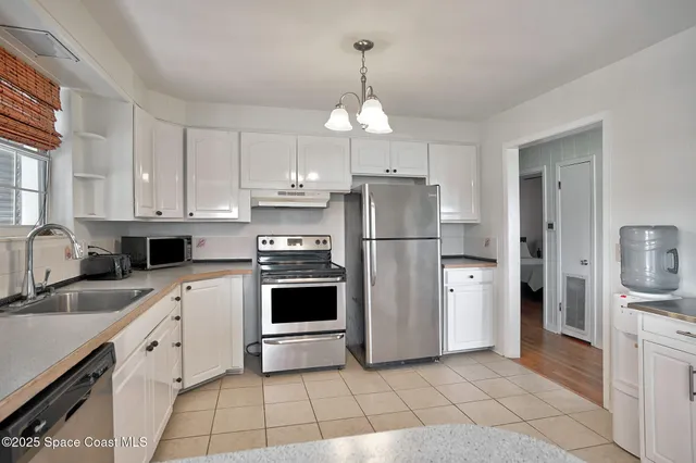 a kitchen with a refrigerator a sink and cabinets