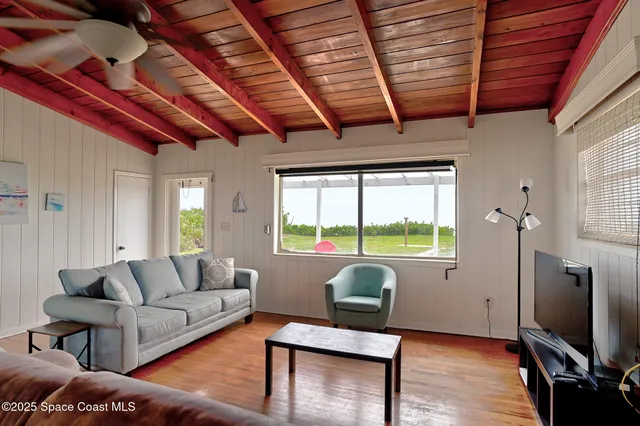 a living room with furniture a flat screen tv and a large window