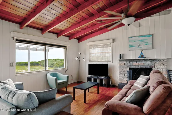 a living room with furniture a flat screen tv and a fireplace