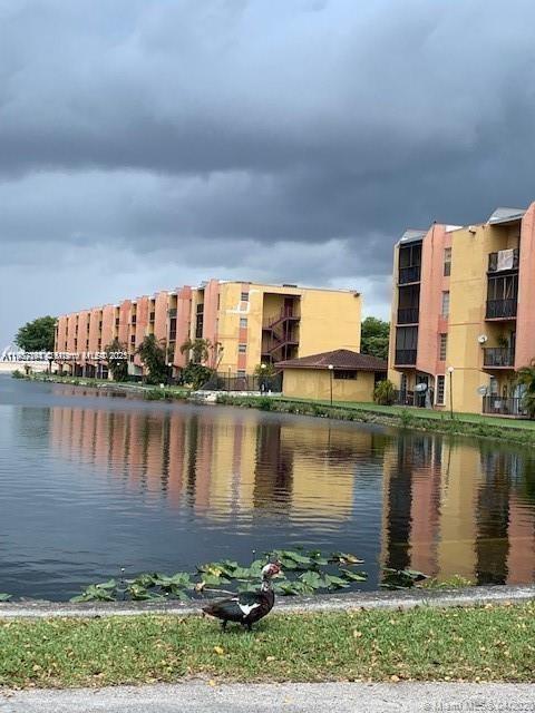 a view of a lake with a big yard and large trees