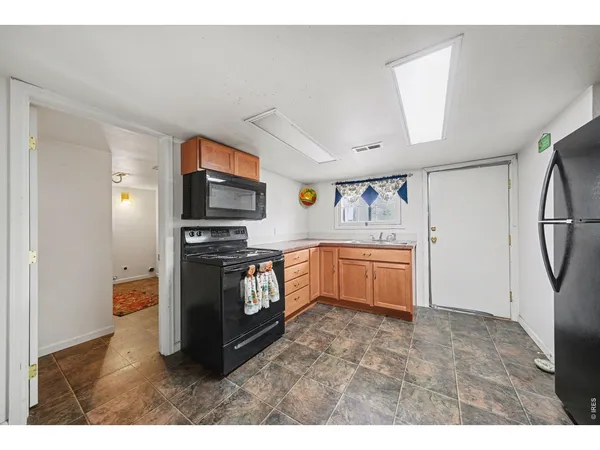 a kitchen with stainless steel appliances a stove top oven a sink and a refrigerator