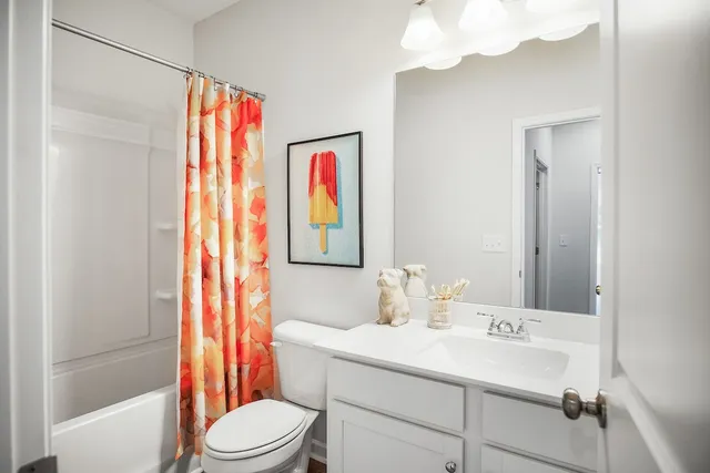a bathroom with a sink vanity mirror and toilet