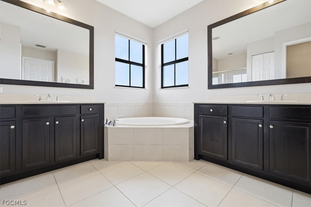 5245 Messina Street Ave Maria, FL 34142 - Photo 20 of 44 a bathroom with a tub sink and mirror
