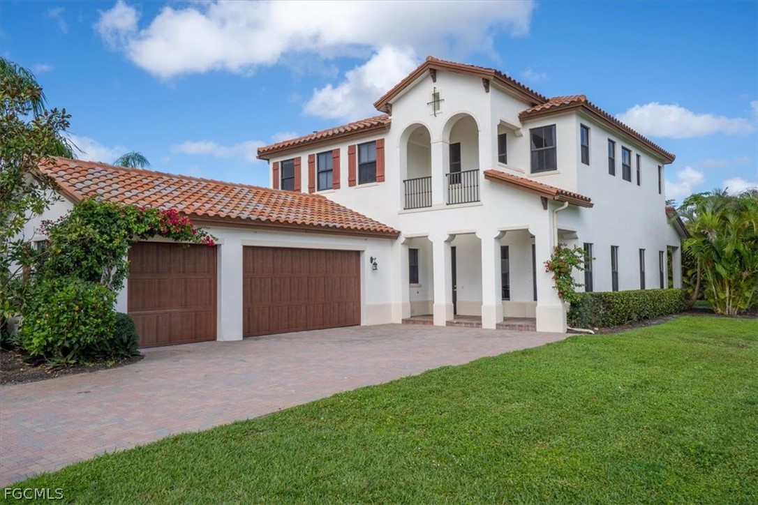 5245 Messina Street Ave Maria, FL 34142 - Photo 2 of 44 a front view of a house with a garden and yard