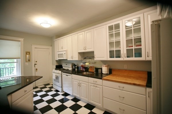 a kitchen with a sink a stove cabinets and a window