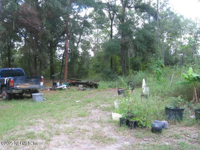 a view of a backyard with lawn chairs and a fire pit