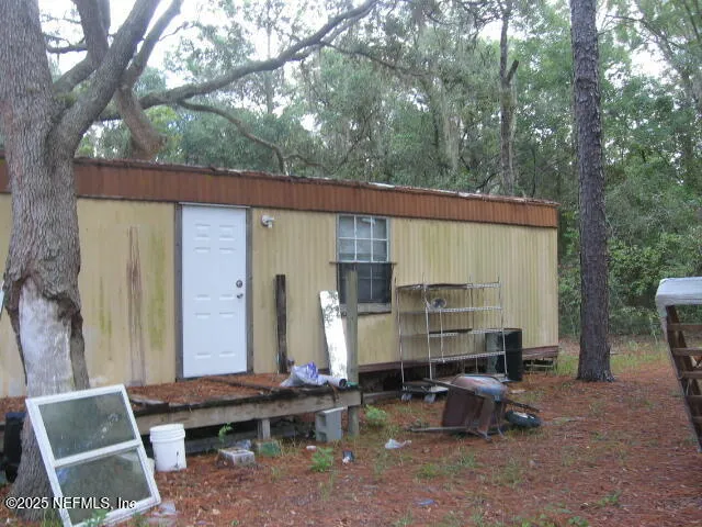 a backyard of a house with barbeque oven table and chairs