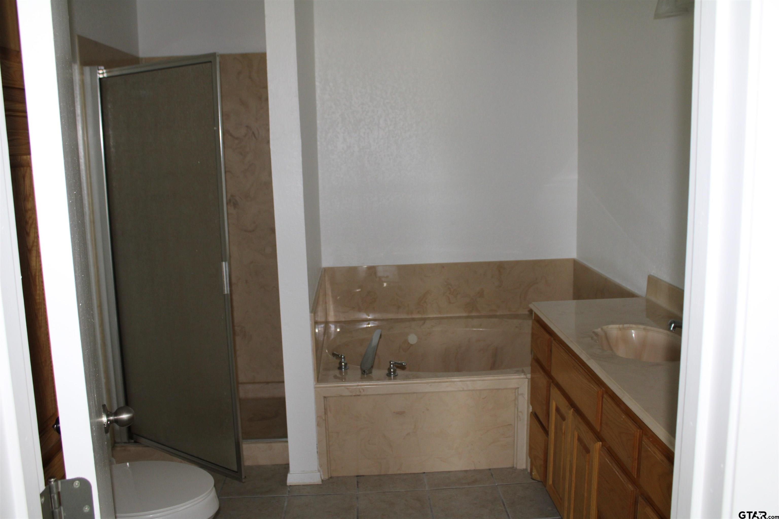 1055 County Road 1314 Rusk, TX 75785 - Photo 14 of 25 a bathroom with a granite countertop sink toilet and tub