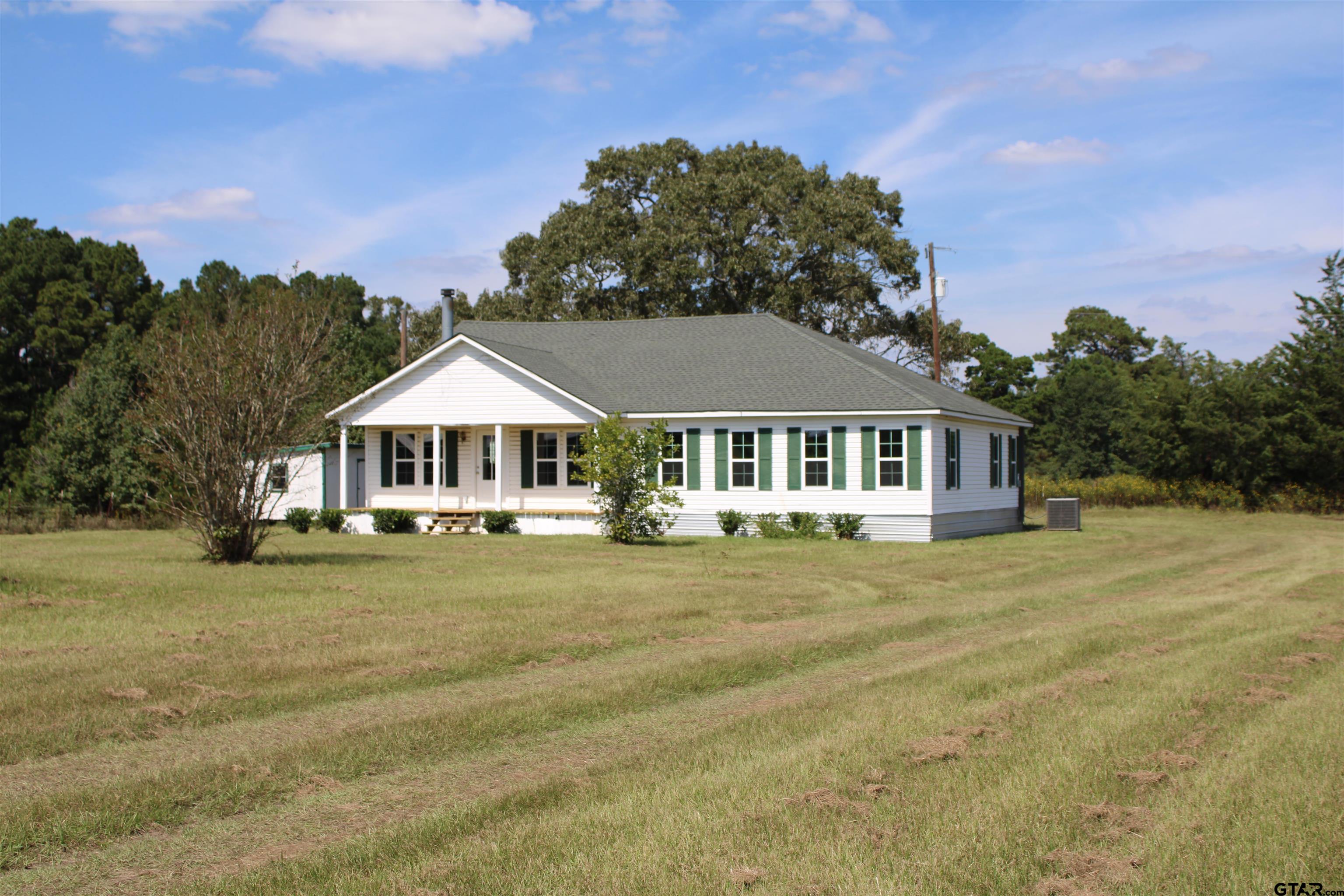 1055 County Road 1314 Rusk, TX 75785 - Photo 20 of 25 a front view of a house with a garden and trees