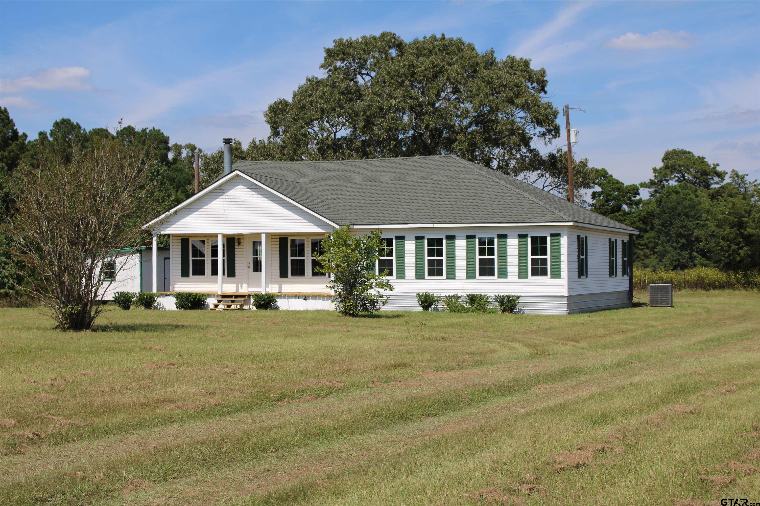 1055 County Road 1314 Rusk, TX 75785 - Photo 2 of 25 a front view of a house with a garden