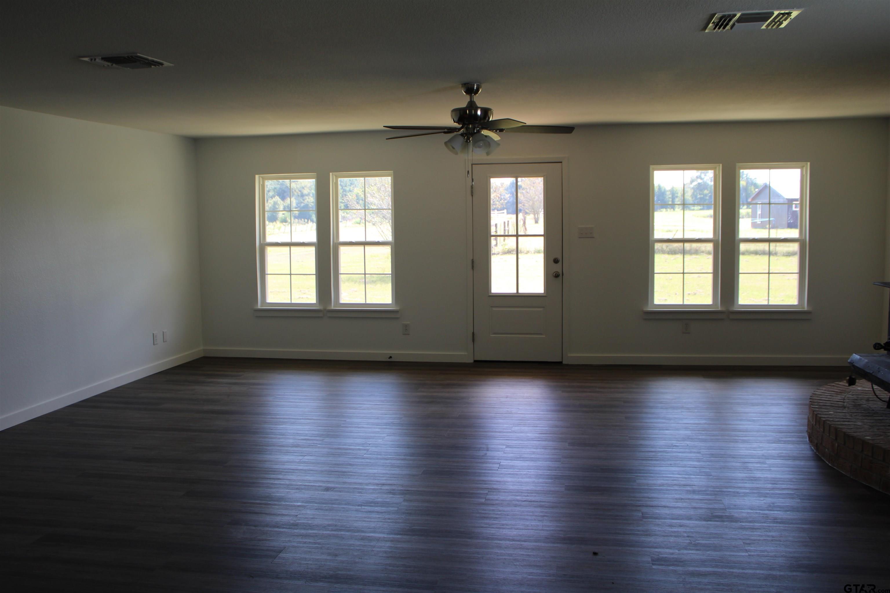 1055 County Road 1314 Rusk, TX 75785 - Photo 4 of 25 a view of an empty room with wooden floor and a window