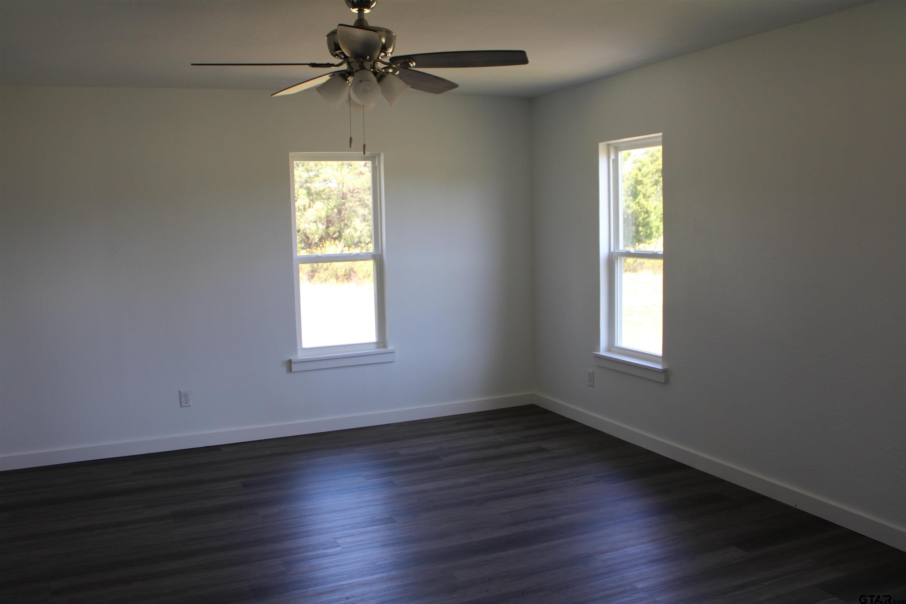 1055 County Road 1314 Rusk, TX 75785 - Photo 10 of 25 a view of an empty room with wooden floor and a window